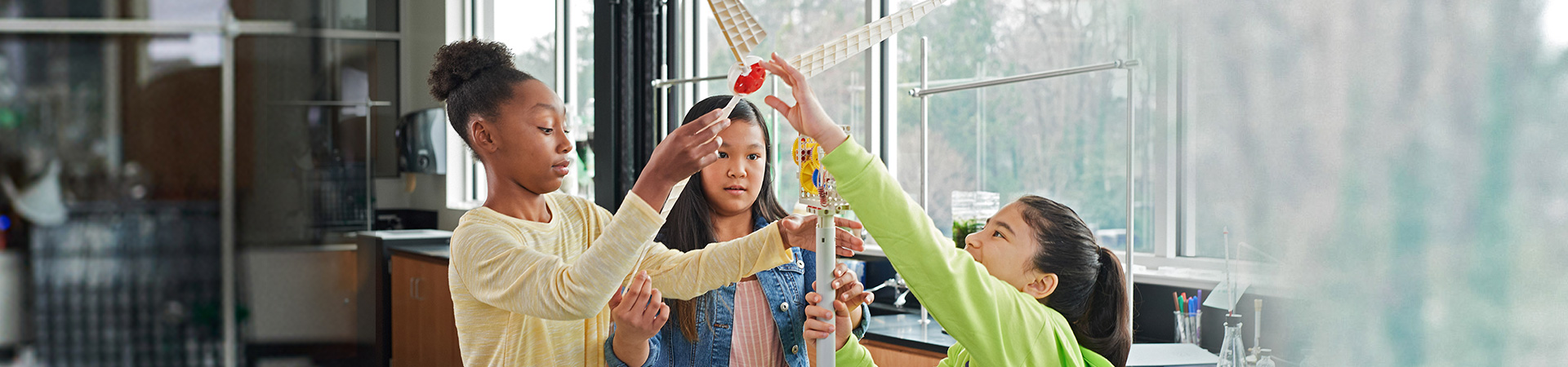  three girl scouts doing stem activity building windmill 