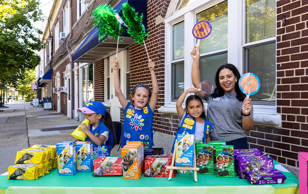 Girl Scout holding boxes of cookies